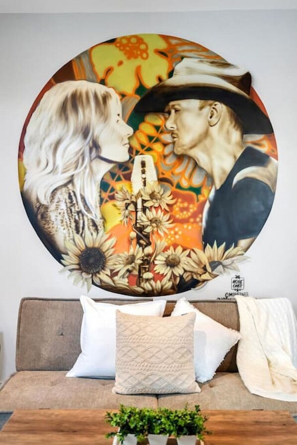 A round painting of a couple on a couch with a floral design and a microphone.