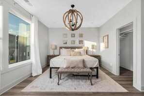A bedroom with a large bed, a bench, a chandelier, and a view through a window. - Tim & Faith's Rooftop - Brand New Nashville Hang Out (Nashville)