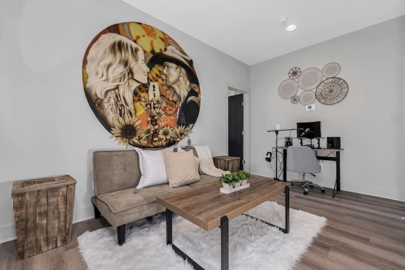 A modern living room with a sofa, coffee table, and a large wall painting.