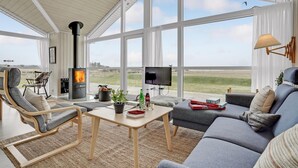A spacious living area with a large window, a fireplace, a television, and comfortable seating. - Cozy home in Fredericia (Fredericia)