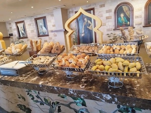 Un bufé con panes y pasteles varios.