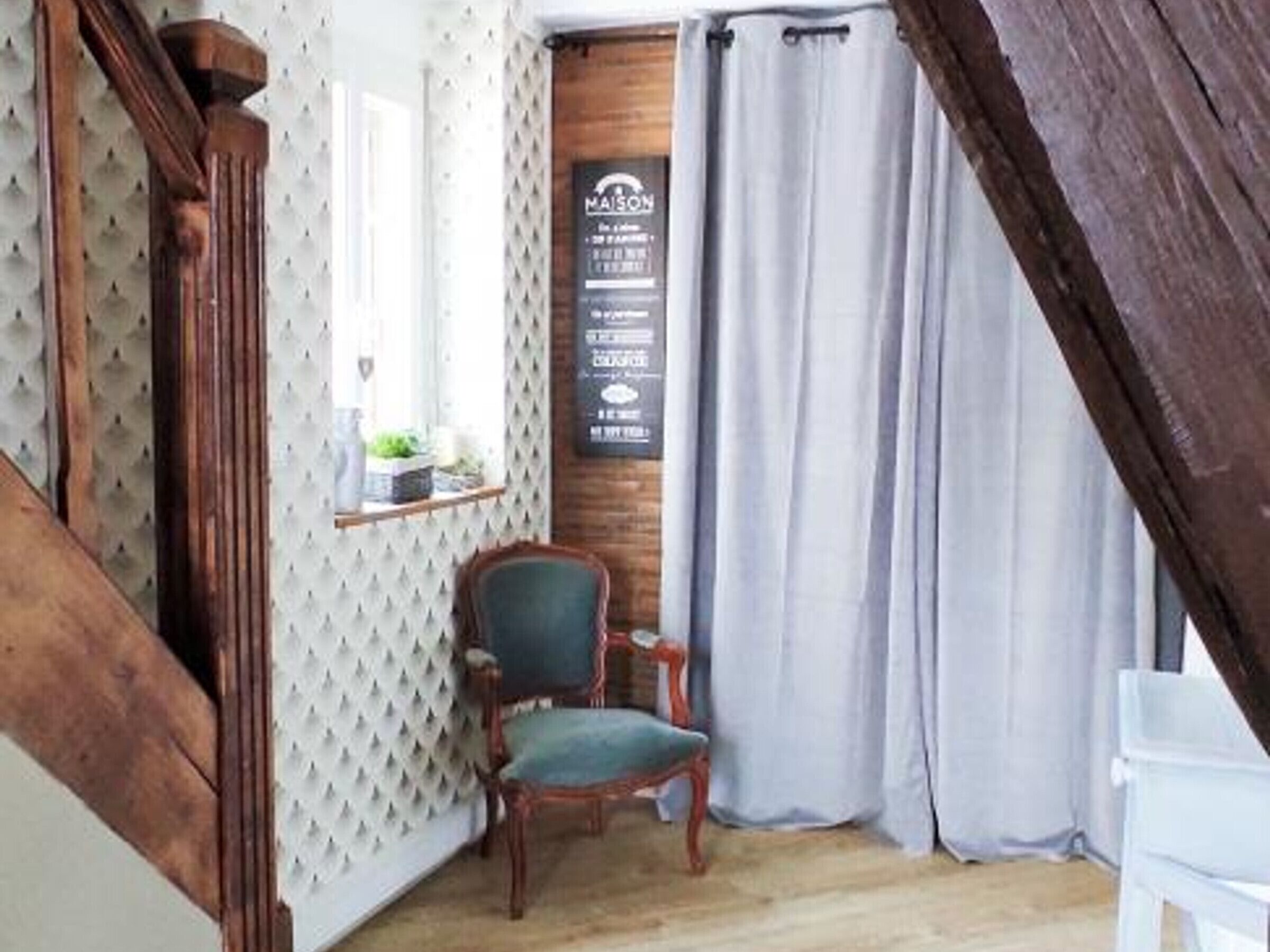 Ein Zimmer mit einer Holztreppe, einem Stuhl, einem Fenster mit Aussicht und einer Tafel mit Schrift.