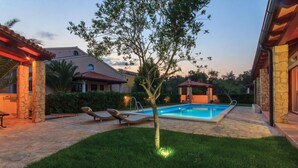 A backyard with a swimming pool, lounge chairs, and a gazebo. - 1 bedroom awesome apartment in Banjole (Banjole)