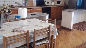 A kitchen with wooden cabinets, a stove, microwave, and a refrigerator. - Modern and Cosy Apartment in Genoa, Italy (Genoa)