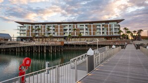 Een hotel aan het water met een modern design, met een houten terras en uitzicht op het water.