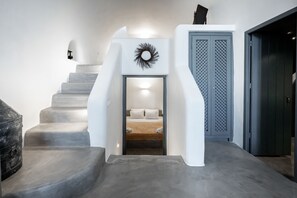 A modern interior with a staircase leading to a bedroom. - Lotza Studios (Santorini)