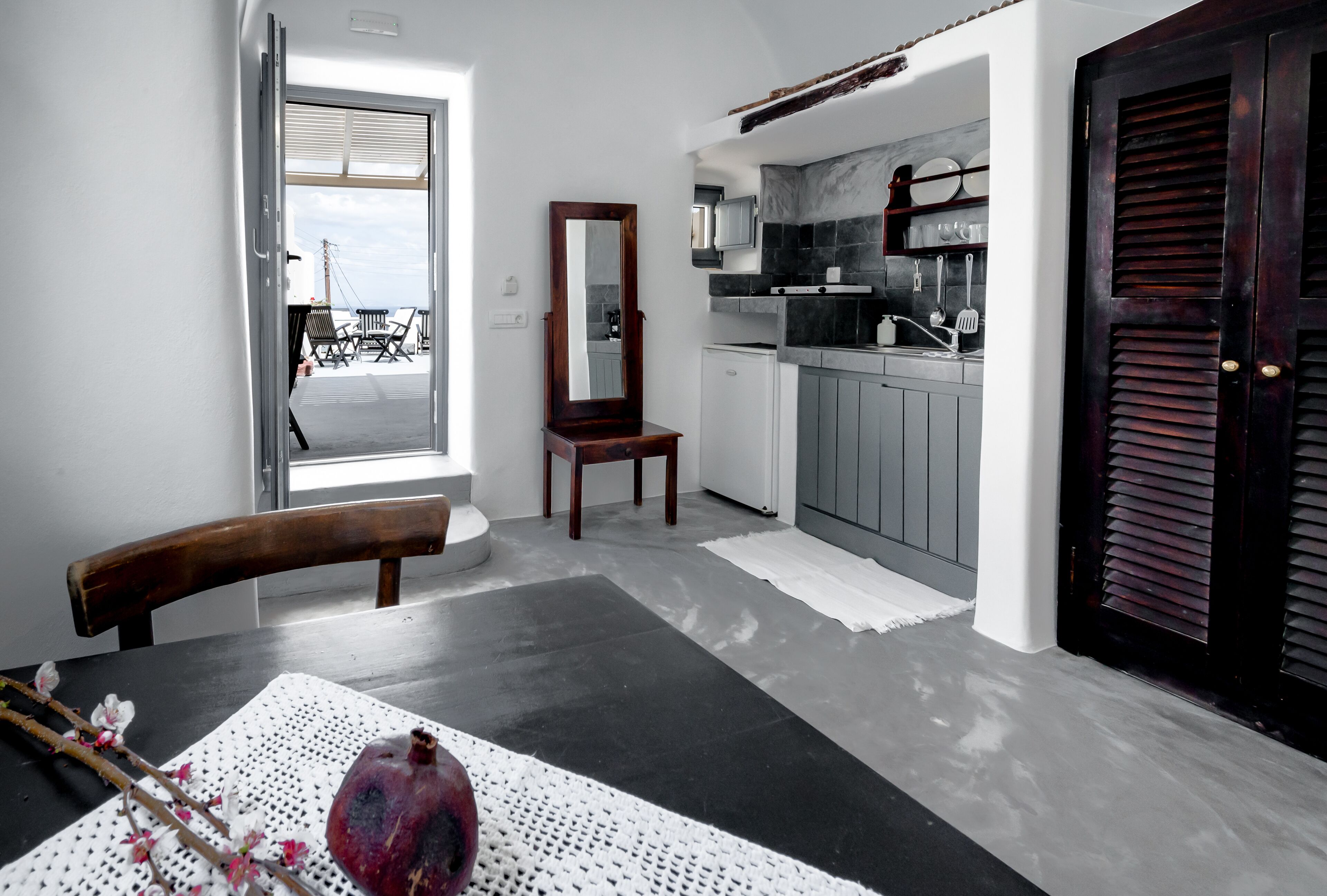 Una cocina moderna con armarios grises, una puerta de madera y vistas al balcón.