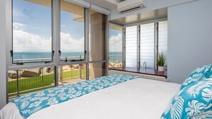 Une chambre avec un grand lit, une vue sur la mer et une porte-fenêtre coulissante.