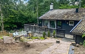 A rustic cabin with a wooden deck, a chimney, and a small porch. - 3 bedroom pet friendly home in Hörby (Hörby)
