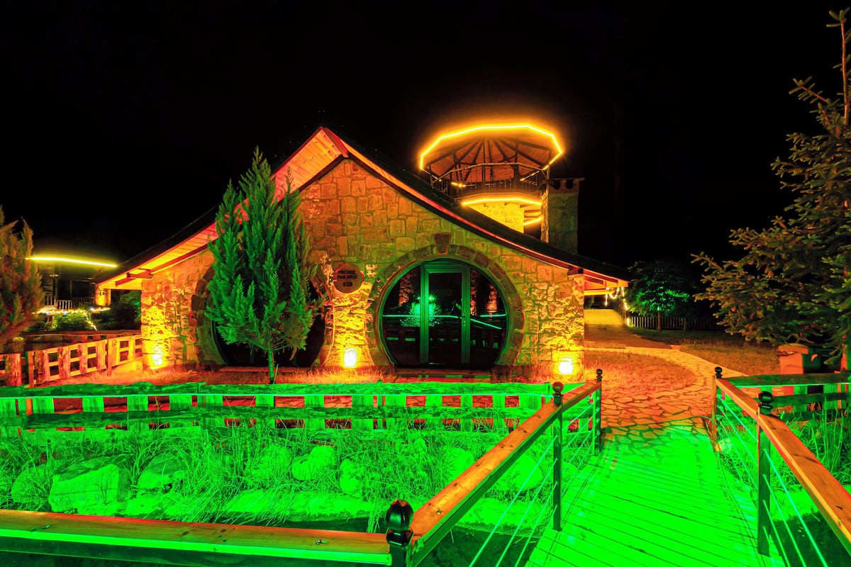 A stone building with a large arched entrance and a circular roof structure.