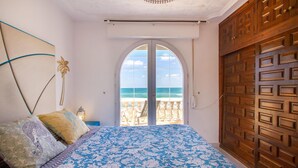 A bedroom with a bed, a view of the ocean, and a wooden door. - Amazing home in Cartagena (Cartagena)