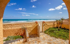 Un sentier de pierres qui mène à une plage d’où l’on a une vue dégagée sur l’océan.