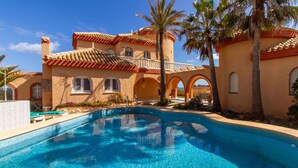 A swimming pool surrounded by a building with arched windows and a tiled roof. - Amazing home in Cartagena (Cartagena)
