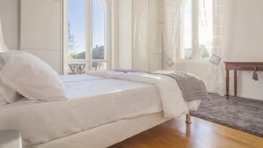 Une chambre à coucher avec un lit, une table en bois et une vue sur l’extérieur par une fenêtre.