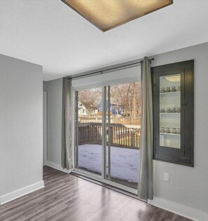 Enjoy a room with a sliding glass door leading to a covered patio offering a view of the surrounding neighborhood.