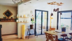 A dining area with a wooden table and chairs, a potted plant, and a shelf with decorative items. - 3 Bedroom Villa in Dingy-Saint-Clair (Dingy-Saint-Clair)