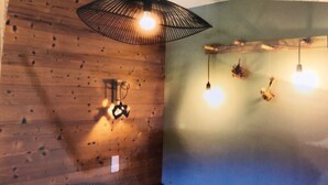 A room with wooden walls, a bench, and hanging lights. - 3 Bedroom Villa in Dingy-Saint-Clair (Dingy-Saint-Clair)