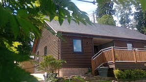 A log cabin with a wooden deck and a small window.