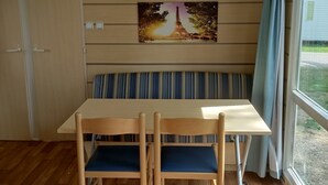 Una habitación con un banco de madera, una mesa y una fotografía de la Torre Eiffel.