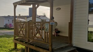Una terraza de madera con un área cubierta, un letrero que dice 