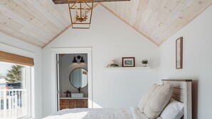 A bedroom with a wooden ceiling, a bed with white bedding, a blue floor, and a woven rug. - Stunning Guesthouse in historic Georgetown w/hot tub! (Georgetown)
