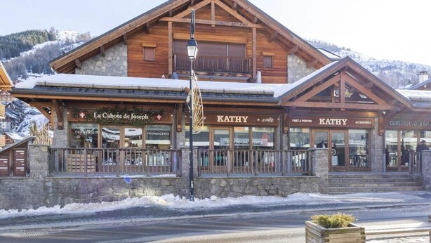 A wooden building with a sign reading 'KATHY' and 'PRET A PORTER'.