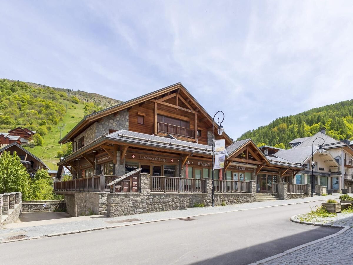 A wooden building with balconies, a stone facade, and a sign reading 'La Cabote de Joseph.'