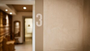 Un couloir avec le chiffre « 3 » peint sur le mur, indiquant le numéro de la pièce.