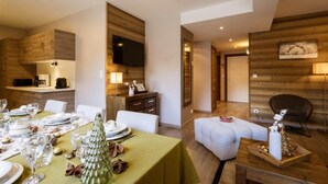 A modern dining area with a wooden accent wall, a flat-screen TV, and a cozy seating arrangement.