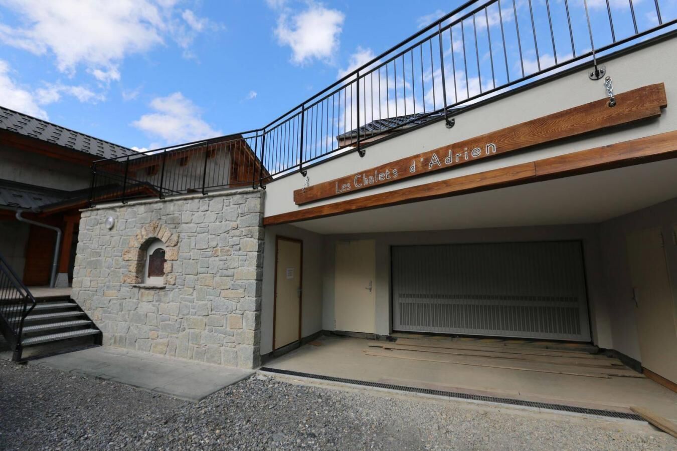 A building with a stone facade, a wooden upper level, and a metal railing.