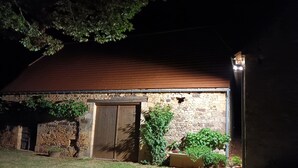 A stone building with a wooden door and a brick roof.