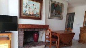Ein Essbereich mit Kamin, Holzmöbeln und zwei Bildern an der Wand.