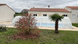 A backyard with a swimming pool, a greenhouse, and a palm tree. - Villa with private pool (Saint-Froult)