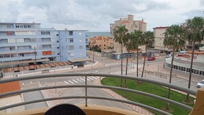 Un balcón con vista a un paisaje urbano, incluyendo edificios y una carretera.