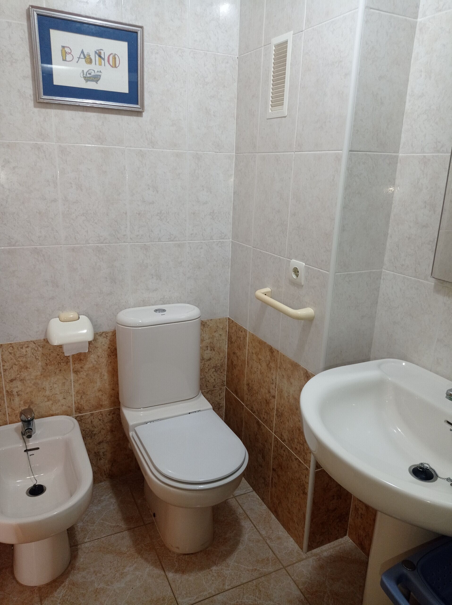 A bathroom with a toilet, bidet, and sink.