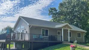 A two-story house with a covered deck, large windows, and a front porch. - Cheerful cottage w/ fireplace. Great location for exploring the Lake Pepin area! (Pepin)