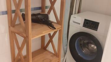 Un estante de madera con una lavadora y un secador en un baño.