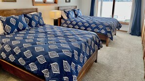 A hotel room with two beds, a ceiling fan, a window with curtains, and a view of a snowy landscape. - Relaxing Ranch Style Waterfront Home--30 minutes from Ann Arbor (Pinckney)