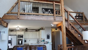 A spacious living area with a high wooden staircase leading to an upper level. - Beautiful, Majestic Log Cabin Large Game Room and Lake View (Wagoner)