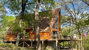 A wooden cabin with a large window, a balcony, and a deck. - Beautiful, Majestic Log Cabin Large Game Room and Lake View (Wagoner)