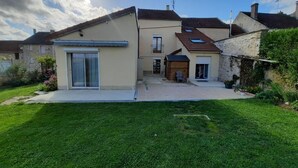 A two-story house with a sloped roof, a front porch, and a well-maintained lawn. - GITE DU SUD DE L'AISNE Rated 3 stars by Aisne tourisme. (Hautevesnes)
