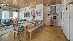 A spacious kitchen with a wooden ceiling, a dining table set for four, and a bench. - Pool-Top Home-Walk to Town! (Port Aransas)