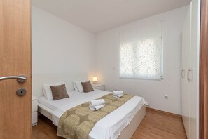 2 habitaciones, escritorio y tabla de planchar con plancha