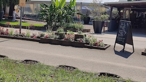 A garden with potted plants and a chalkboard sign. - Smart Home Athens with terrace, ~15 min Europapark, Rulantica (Boofzheim)