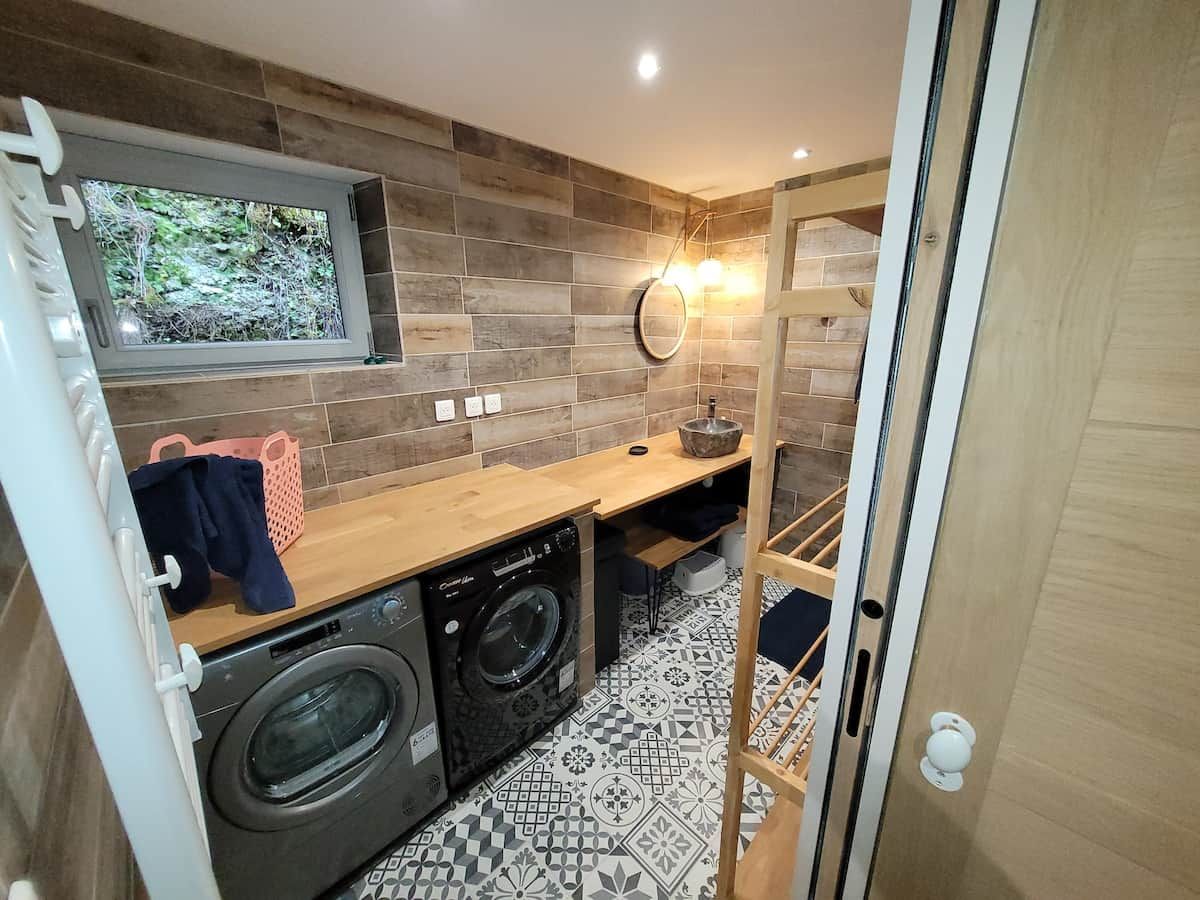 A compact laundry area with a washing machine, dryer, and a wooden counter.