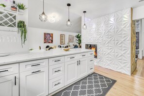 A modern kitchen with white cabinetry, pendant lighting, and a geometric wall paneling. - 3 bedroom villa in bridgeport (Bridgeport)