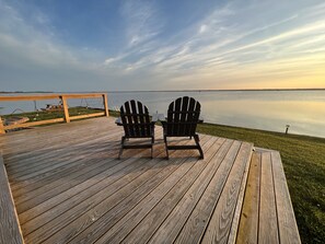 Two Adirondack chairs on a wooden deck overlooking a calm body of water. - Tiny House on Sunset Point - Back Bay (Virginia Beach)