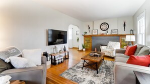 Un salon avec une cheminée, un téléviseur et un canapé.