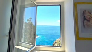 A room with a small window overlooking a coastal view. - Apartment La Scogliera - Riomaggiore (Riomaggiore)