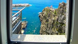 A coastal view from a window, featuring a rocky cliff, a clear blue sea, and a balcony with a railing. - Apartment La Scogliera - Riomaggiore (Riomaggiore)